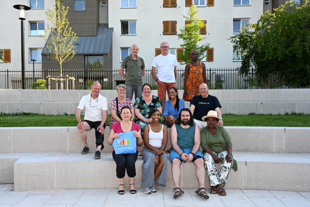 Groupe des représentant du conseil citoyen assis sur les marche de la place Jacques-Brel.