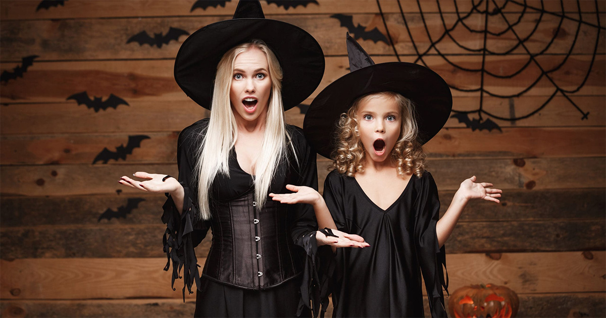 une maman et sa fille déguisées en sorcière sur un fond type halloween avec des décors d'araignées et des toiles et des chauves souris.